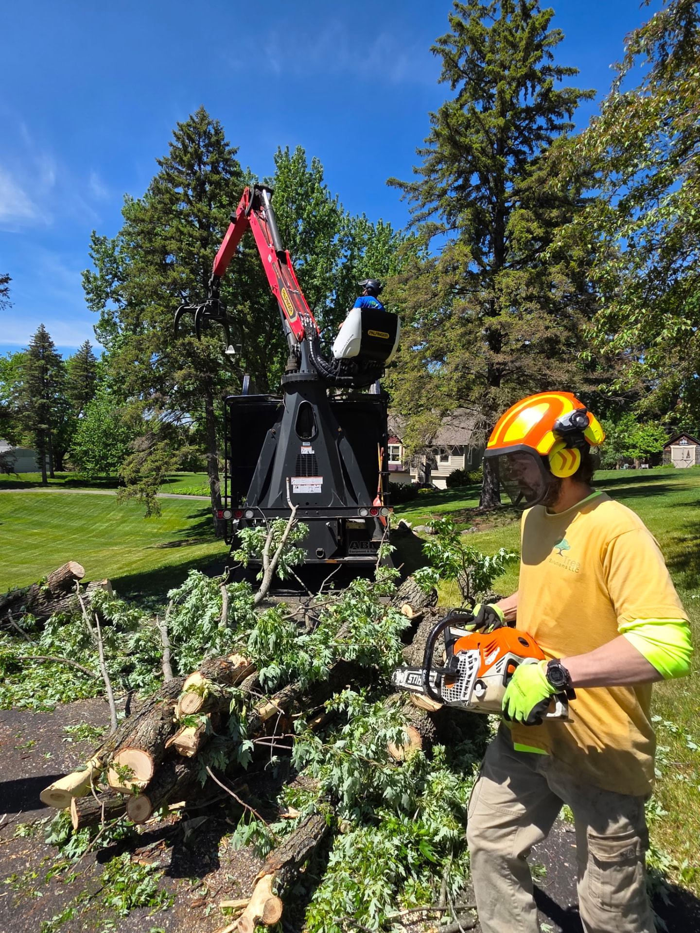 Crew processing cut logs and limbs with a grapple truck