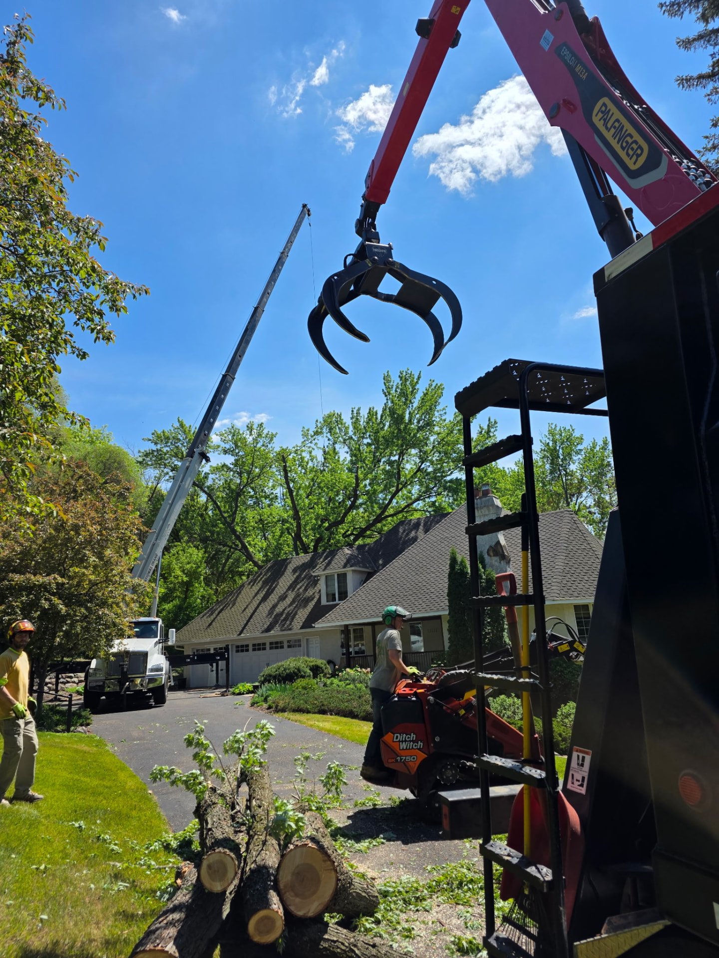Palfinger grapple and Ditch Witch track loader working a driveway removal