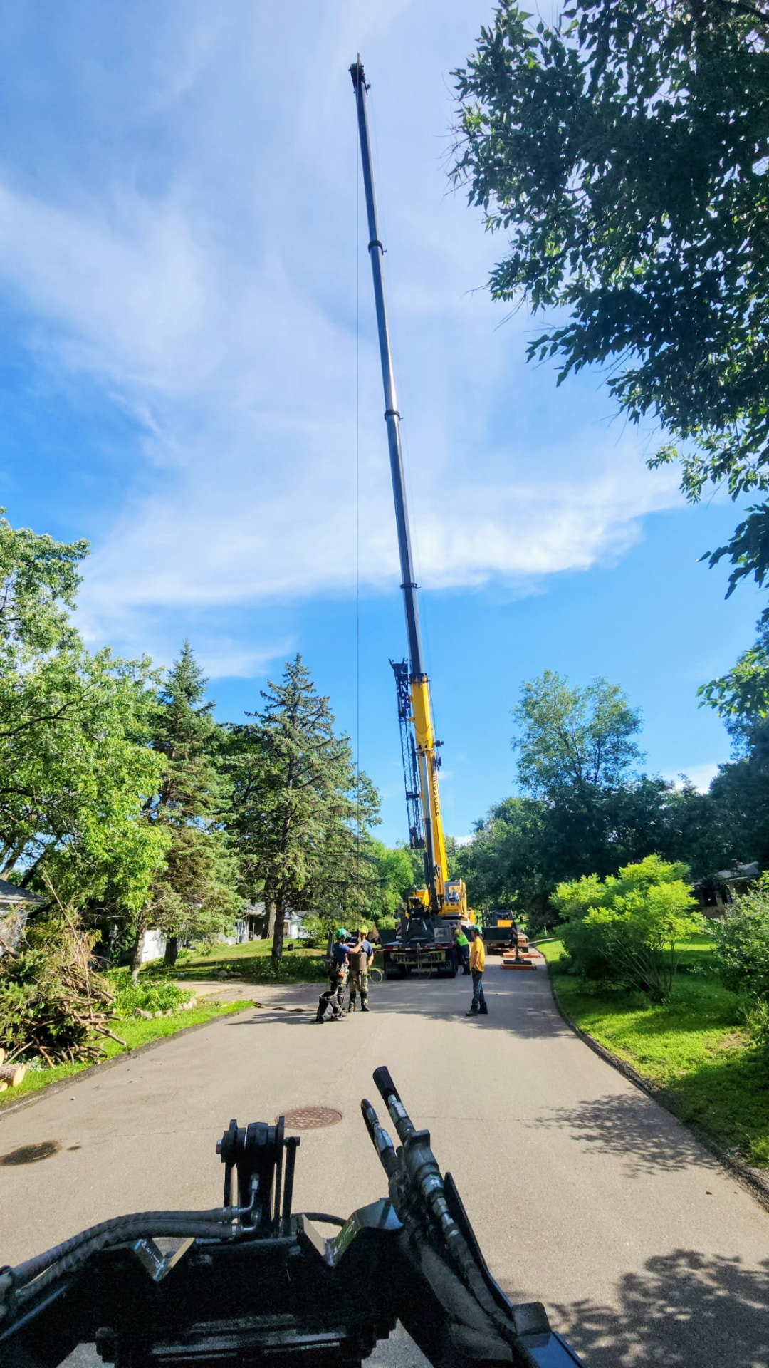 All-terrain mobile crane staged on a residential street for a large removal
